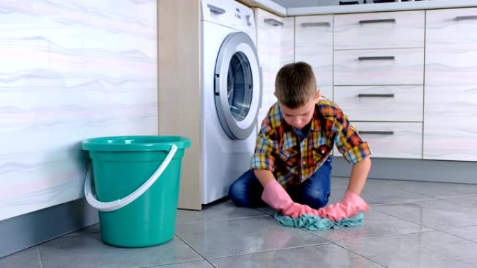 戴橡胶手套的疲倦男孩不想在厨房洗地板。脱下手套扔在地板上。