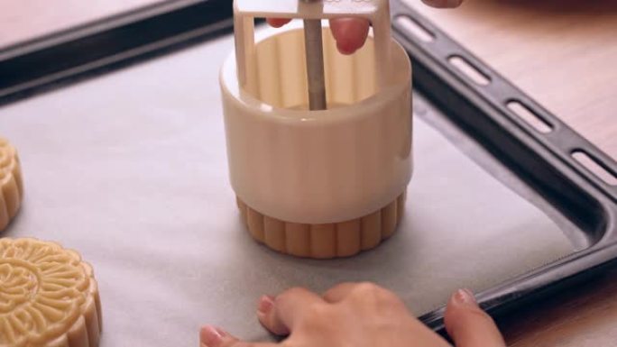 中秋节月饼的制作过程-在烤盘上成型月饼糕点的形状。女性节日自制概念。