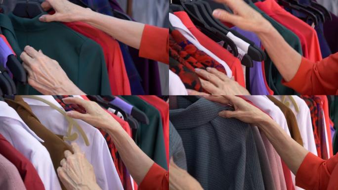 老年妇女在购物时在时装店选择衣服的手