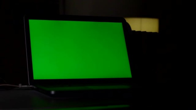 笔记本电脑绿屏，家庭办公室，多莉拍摄。色度键笔记本电脑。