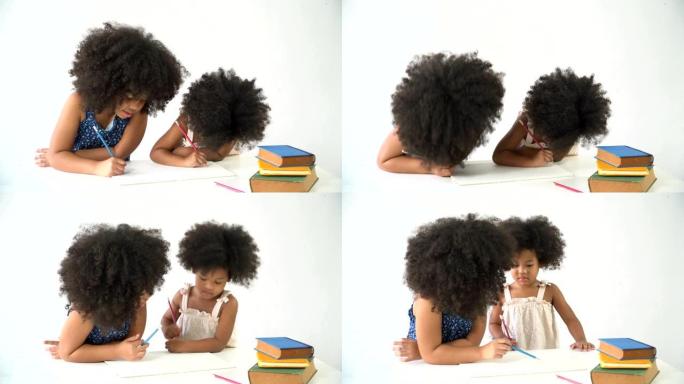 两个可爱的非洲泰国小女孩一起学习写作。大姐劝小妹怎么写