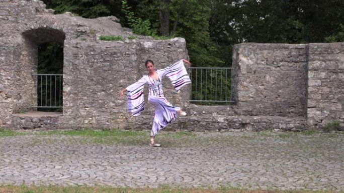 芭蕾舞女演员在一座古老城堡的废墟附近的大自然中跳舞