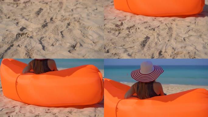 一个年轻女子在热带海滩上坐在充气沙发上的慢镜头。暑假概念