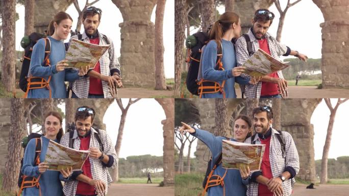 快乐的年轻夫妇背包客游客阅读地图指南，在罗马公园广场的罗马渡槽拱门附近迷失方向