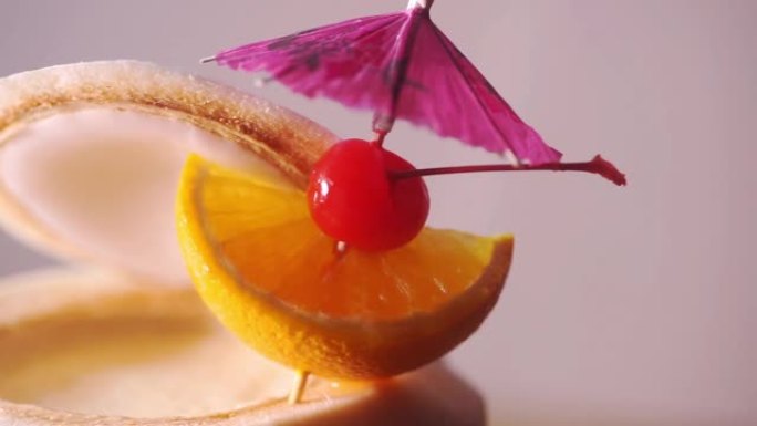 热带新鲜椰子鸡尾酒装饰有雨伞、橙片和樱桃樱桃。