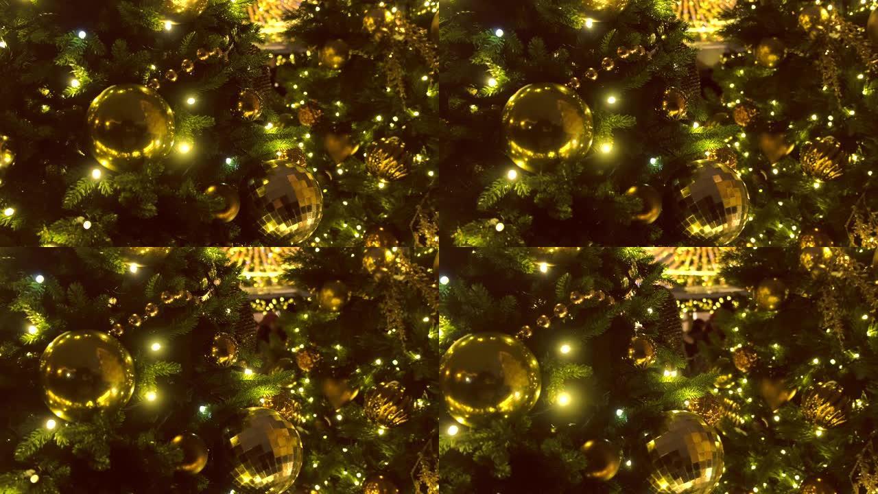 圣诞树的树枝上有金色和花环的圣诞球，特写镜头。