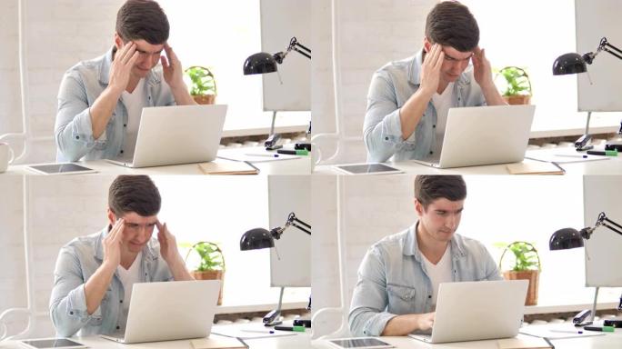 紧张的年轻人在笔记本电脑上工作时头疼