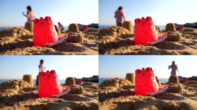 海滩上制作沙堡的红色塑料桶