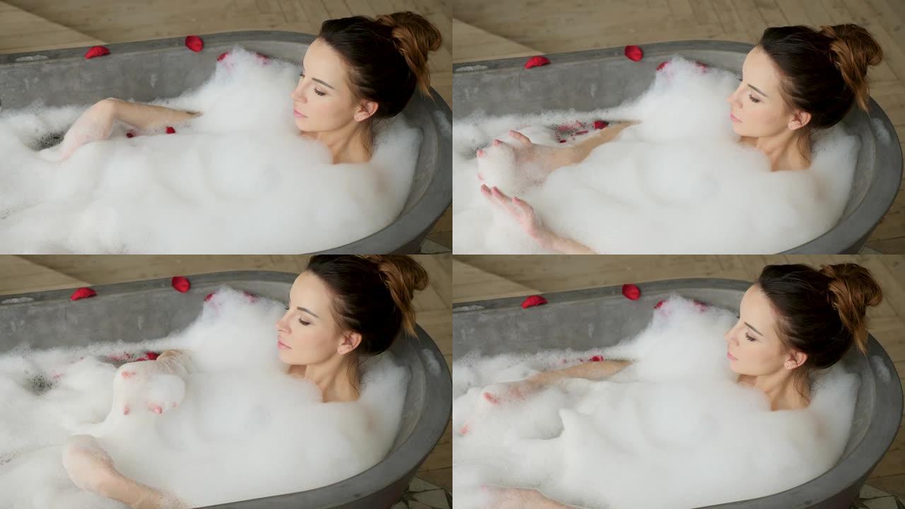 女孩躺在泡沫中的大石浴中