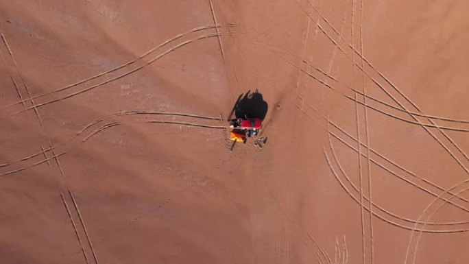 空中俯视图在沙漠中停留，露营地有帐篷，火和全轮驱动汽车，在世界上最干燥的沙漠阿塔卡马沙漠中进行惊人的