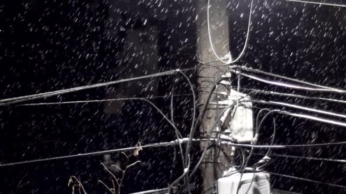 漆黑的夜晚，街道下的密集雪花与电缆线安装