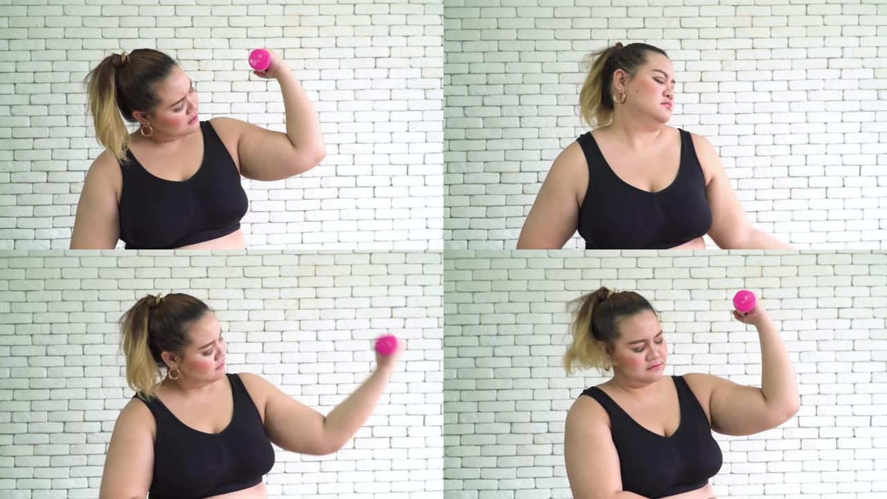 泰国超重女人厌倦了用粉色哑铃锻炼来减少宾果翅膀