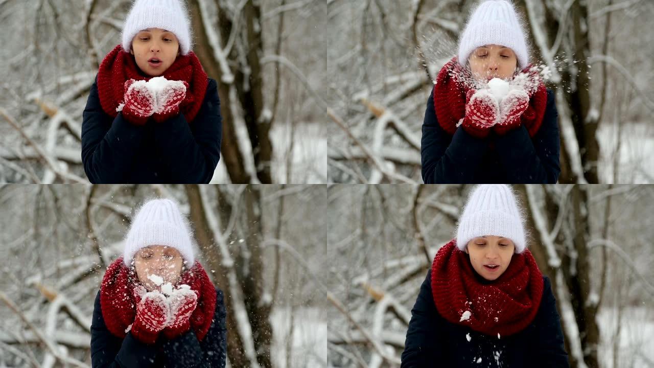 穿着白色针织帽，红领巾和连指手套的年轻女孩吹雪