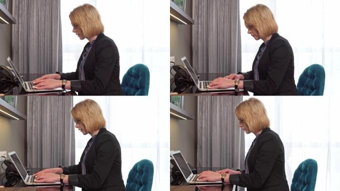 成熟的金发女人在笔记本电脑上做会议的演示
