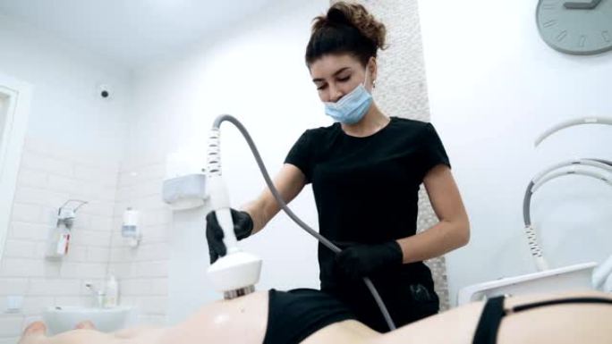 专注于美容师对患者的臀部进行抗脂肪处理，慢动作