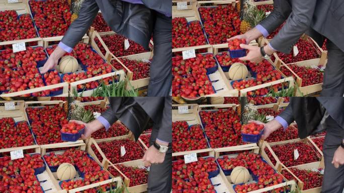 一个人从水果市场买草莓