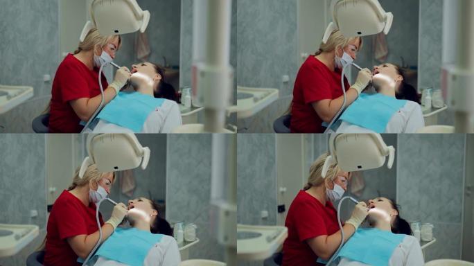 美丽的女人牙医治疗一个女孩的牙齿，钻一颗牙齿。口腔卫生程序完成后，钻头卸下机架上的工具。