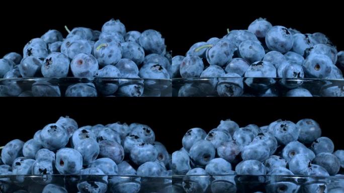 黑色背景玻璃器皿中的新鲜蓝莓。特写，相机旋转360度。沼泽越橘、沼泽蓝莓、北方越橘或西方蓝莓 (Va