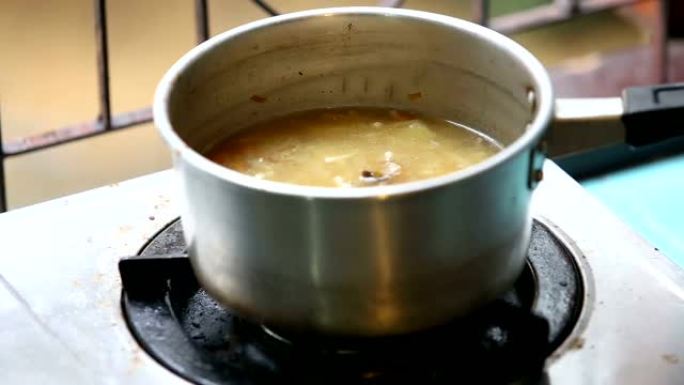 在平底锅中搅拌汤勺鸡汤