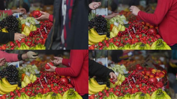一个人在绿色市场上只买一个西红柿并免费获得黄瓜的镜头