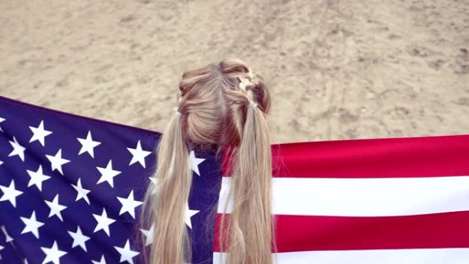 带有美国国旗的金发女孩的后视图