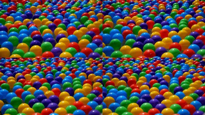 彩色的小塑料球在水中漂浮和移动，特写。