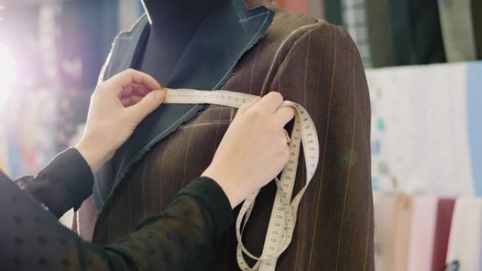 裁缝用卷尺在一件新的棕色夹克上采取措施