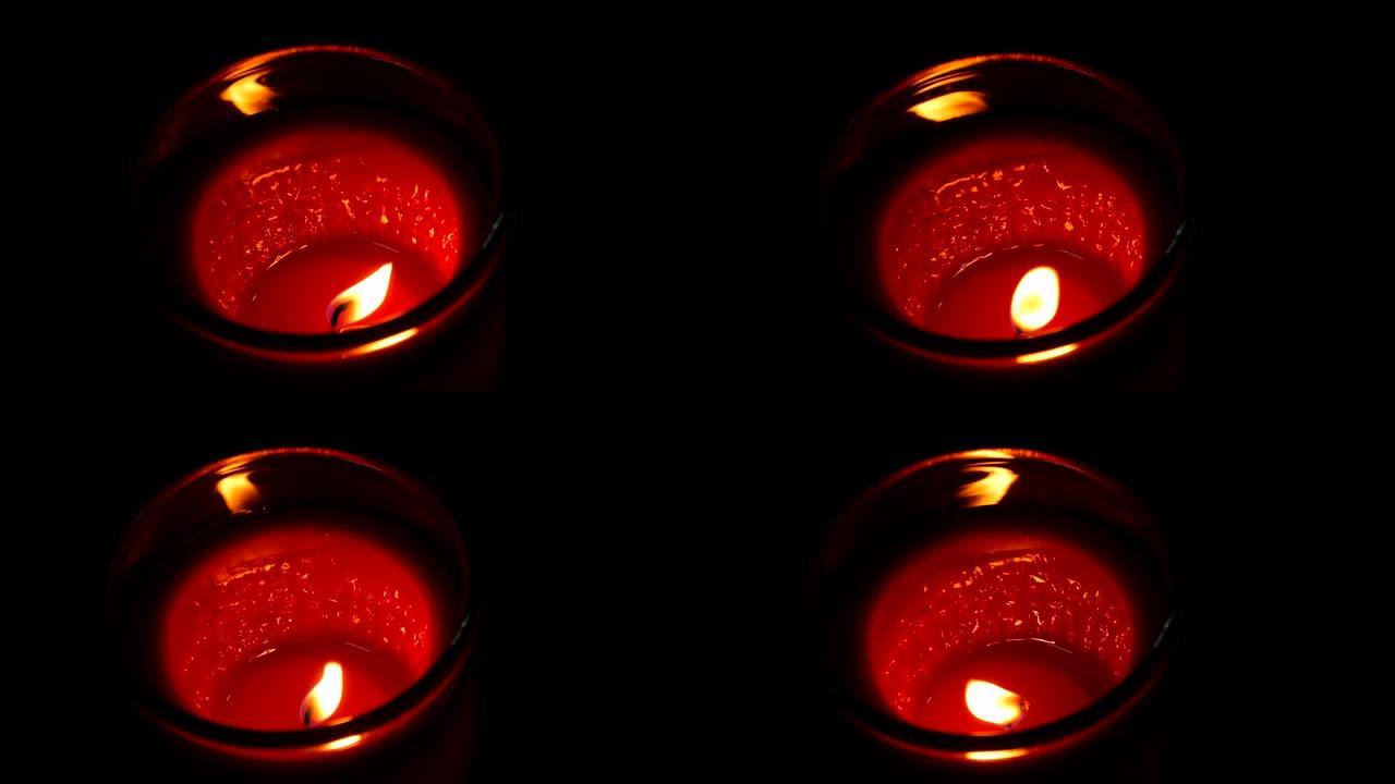 大型圆形红色纪念蜡烛在黑暗中燃烧