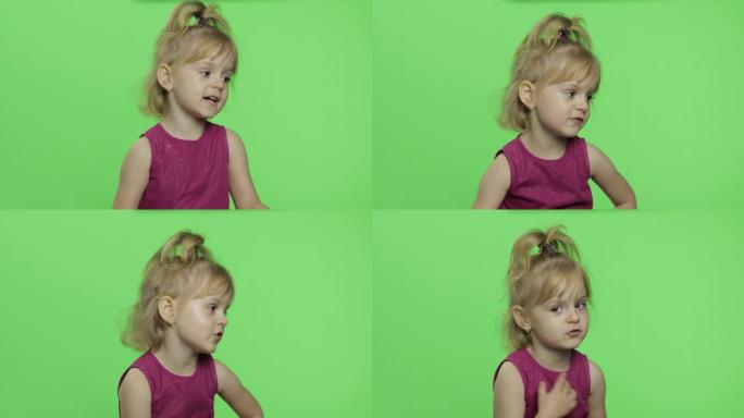 穿紫色连衣裙的女孩讲述了一些事情。快乐的四岁孩子。色度键