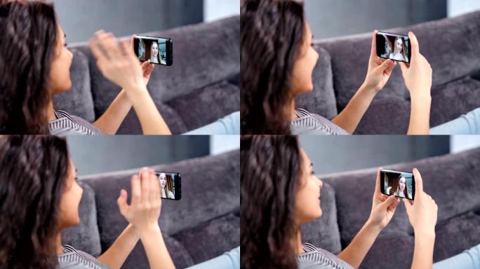 微笑的年轻女子使用智能手机特写与女朋友进行视频聊天