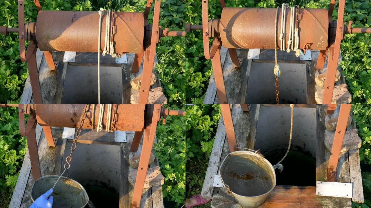 女人用水桶把链子扔进乡村井取水。老式水井链特写。村子里老生锈的铁链。