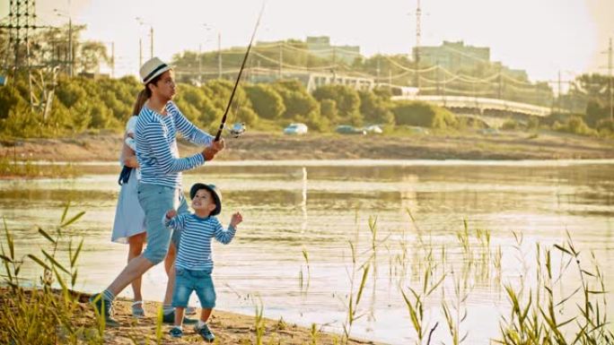 家人在钓鱼-父亲拿着钓鱼竿，向儿子展示如何钓鱼