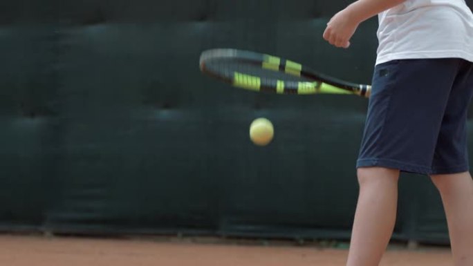 打网球时，职业男孩网球运动员在球场上用球拍将球抛向空中并击打
