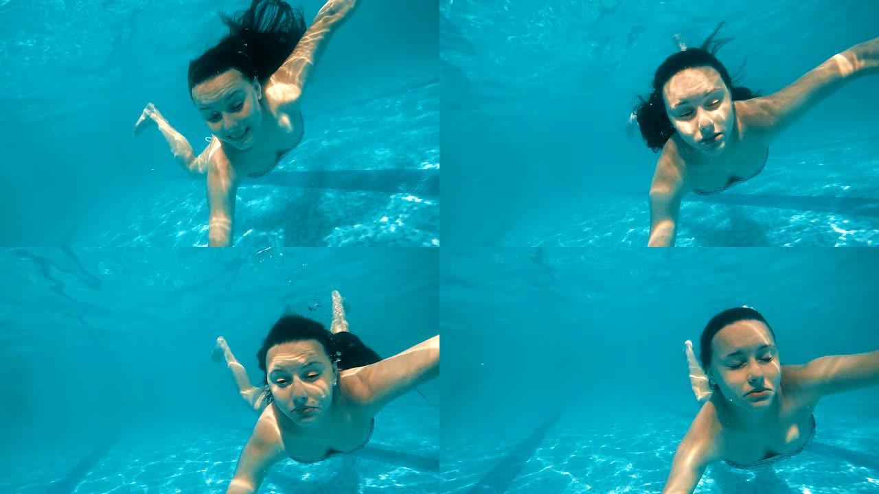 十几岁的女孩在游泳池里惊慌失措地让鬼脸淹没在水下，慢动作