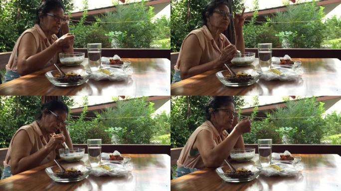 资深亚洲妇女在家吃饭