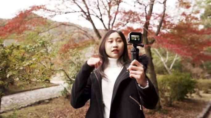 年轻的亚洲Youtuber在日本秋季假期与相机交谈