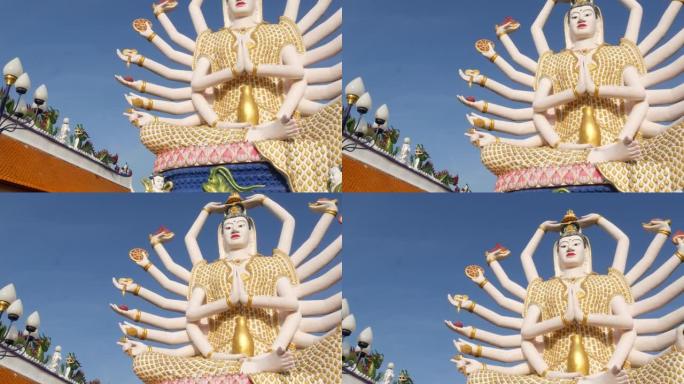 佛寺院子里的观音像。关阴雕像，多臂，位于东方国家传统佛教寺庙院子里，面对万里无云的蓝天。Wat Pl