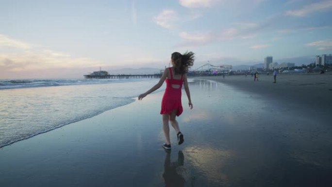 在圣莫尼卡海滩上跑步的女孩