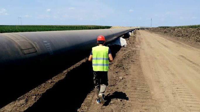 工人在输油管道旁行走-空中无人机跟踪拍摄