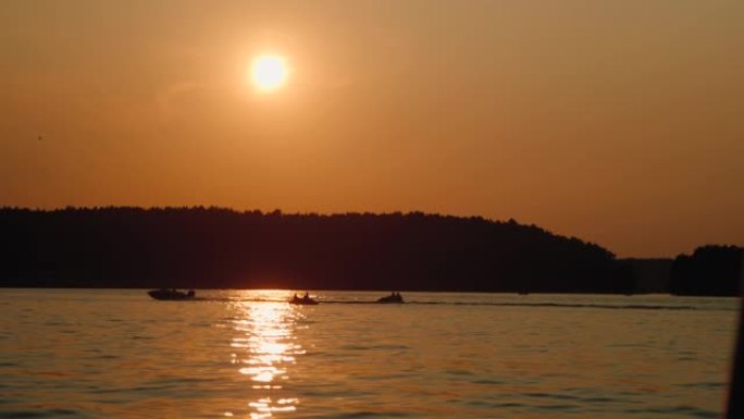 摩托艇在日落时向湖中驶去