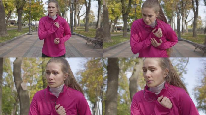 穿着粉红色运动服的迷人白人妇女在跑步时因胸痛而停下来