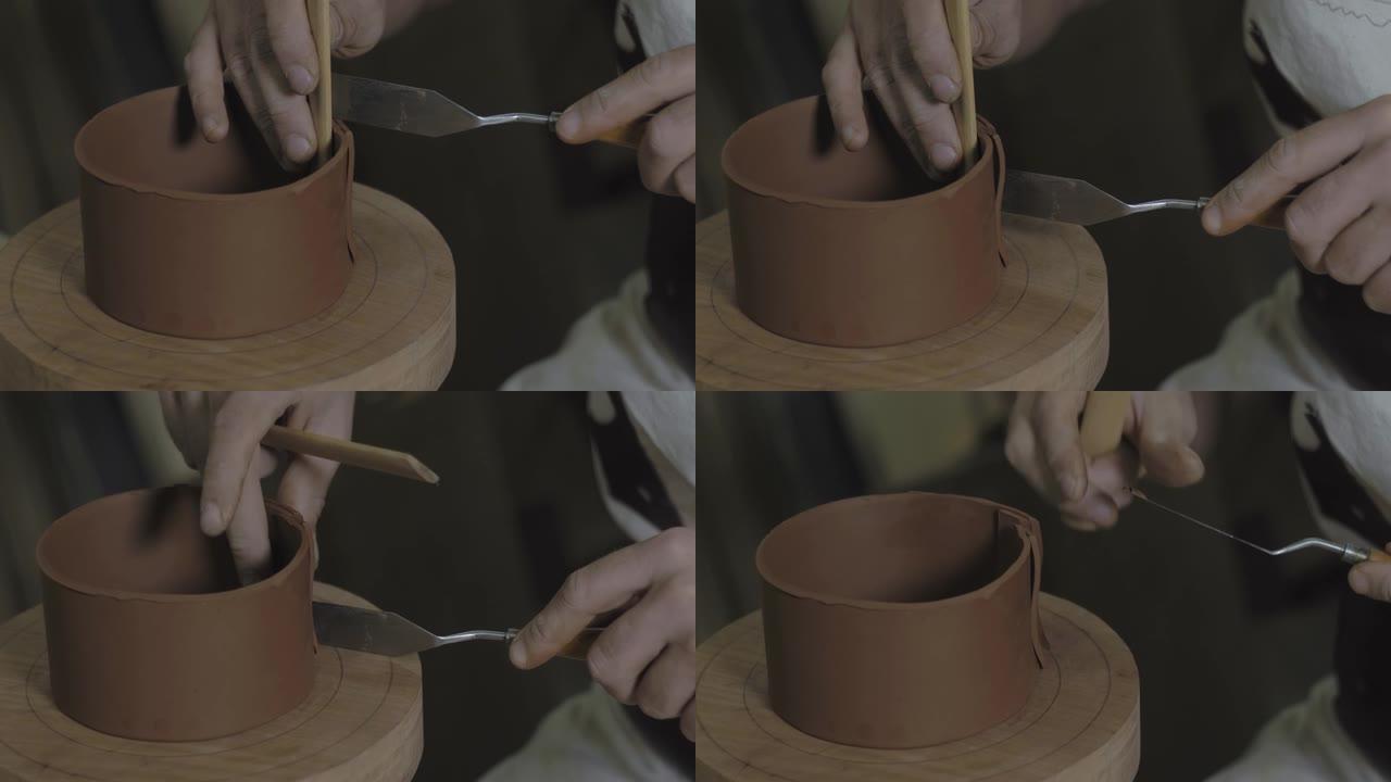 双手合拢切掉木制平台上的粘土条边缘，用于用宜兴粘土制作茶壶。手工制作的陶制茶壶宜兴茶道。紫色陶茶壶。