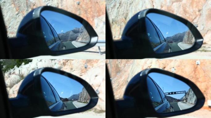 在美丽的蓝天下行驶中的汽车镜子上的高速公路