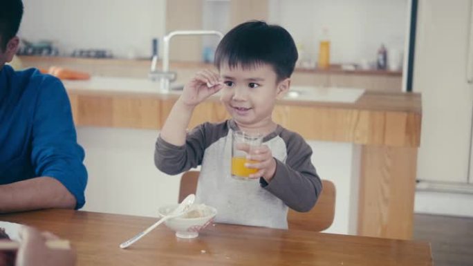 亚洲小男孩吃米饭喝果汁