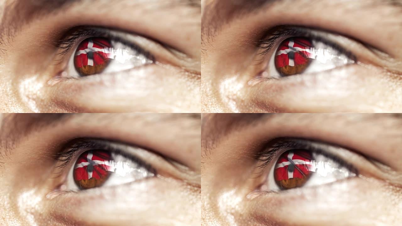 男人棕色的眼睛在近距离与丹麦国旗在鸢尾，与风的运动。视频的概念