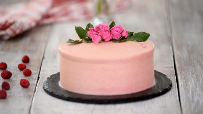 用粉红巧克力豆装饰蛋糕的过程。用饼干和奶油馅，浆果烹饪多层蛋糕。生日聚会或婚礼用自制蛋糕。