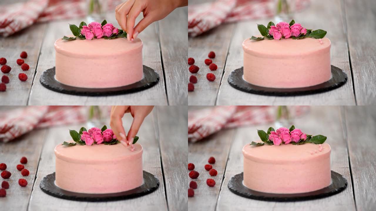 用粉红巧克力豆装饰蛋糕的过程。用饼干和奶油馅，浆果烹饪多层蛋糕。生日聚会或婚礼用自制蛋糕。
