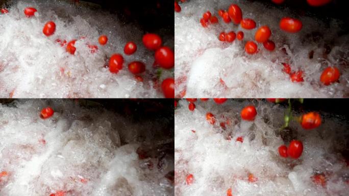 在慢动作的番茄加工厂中，许多新鲜的西红柿落在泡沫中并溅起了水。它看起来鼓舞人心，令人愉悦。