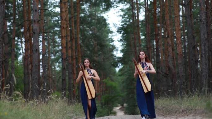两名女竖琴手走在林道，弹奏竖琴。