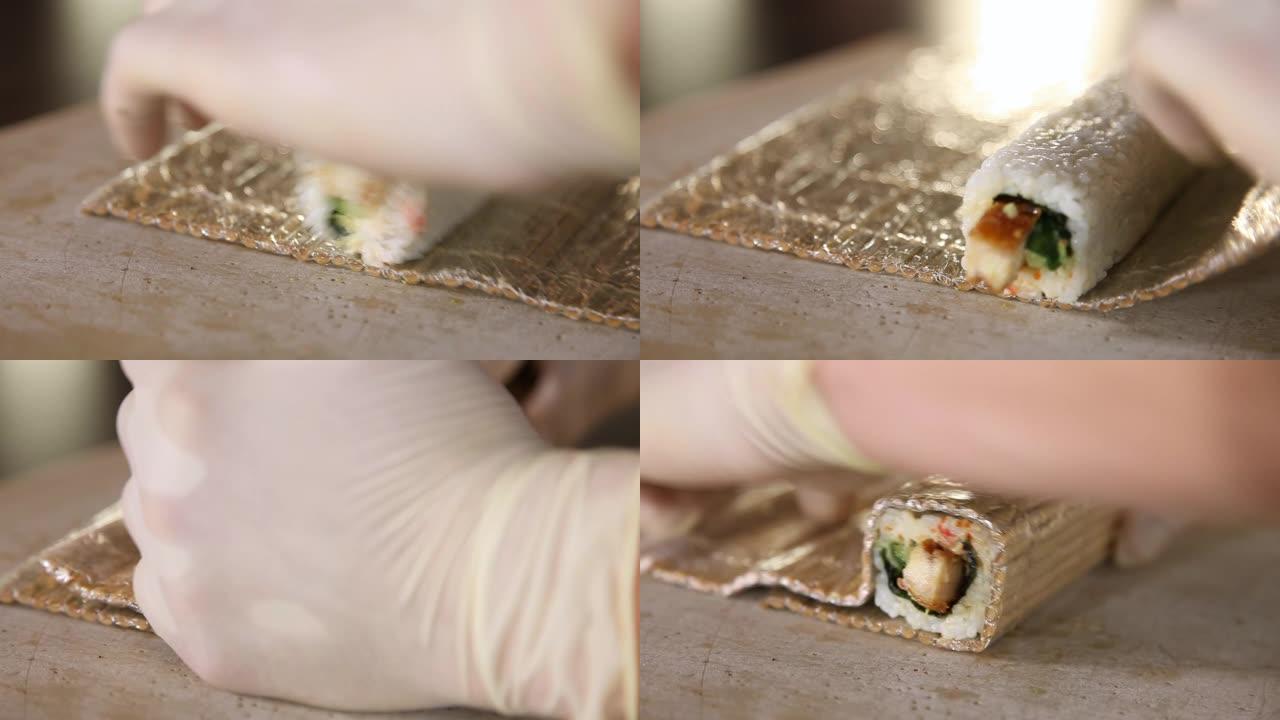 寿司制作过程。把寿司卷卷在竹席上。寿司卷的配料堆放 -- 米饭、黄瓜、烟熏鳗鱼。特写。厨师的手